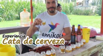 Cata de cerveza gay Hombre sonriente sosteniendo un vaso de cerveza en una cata, con botellas y botanas.