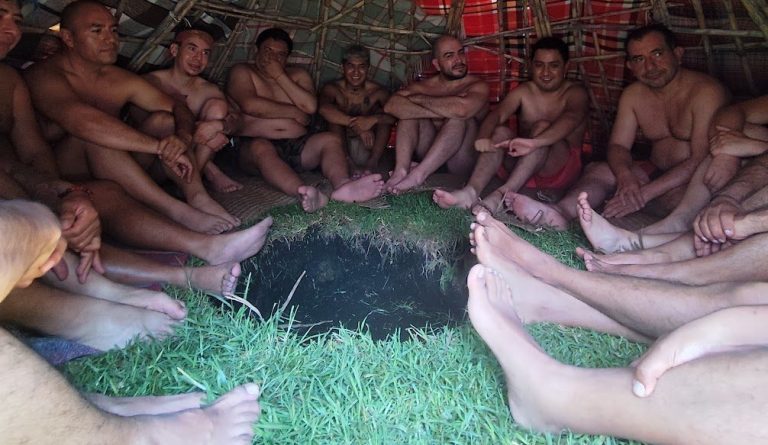 Temaxcal gay Xochimilco Grupo de personas sentadas en círculo, descalzas, sobre hierba en un entorno natural.