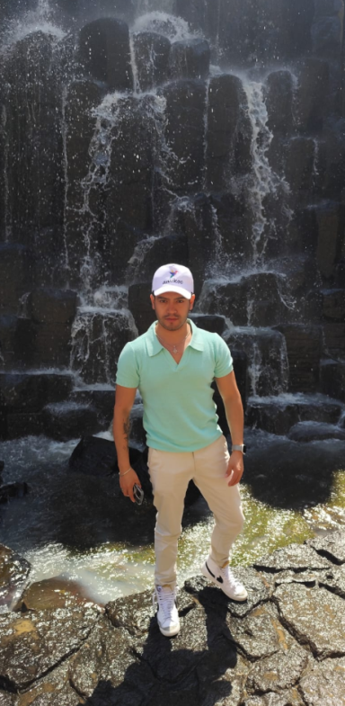 Tours Viajes gays a los Prismas Basálticos en Hidalgo, Saliendo de Ciudad de México Cascada sobre rocas, con vegetación y cielo azul al fondo.