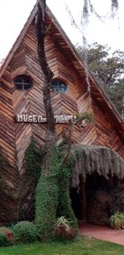 Tours Viajes gays al museo de los duendes en Hidalgo Casa con arquitectura de madera y detalles en forma de diamante, rodeada de vegetacin.